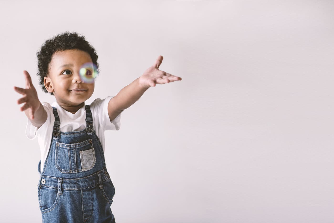 A toddler reaching toward a bubble